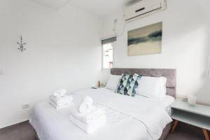 a bedroom with a white bed with towels on it at Arenda Tel Aviv - Rothschild Boulevard Apartments in Tel Aviv