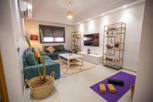 Majorelle Splendide Appartement في مراكش: غرفة معيشة مع أريكة زرقاء وطاولة