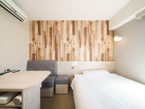 a bedroom with a bed and a desk and a table at Super Hotel Chiba Ekimae in Chiba