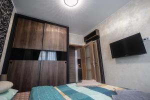 - une chambre avec une grande armoire en bois et une télévision dans l'établissement Luceafarul Property, à Oradea
