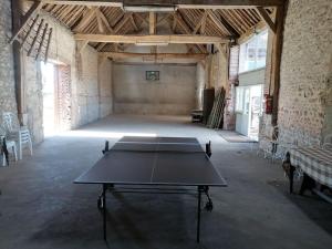 eine Tischtennisplatte in einem leeren Raum in der Unterkunft La ferme du Petit Chavernay in Meslay-le-Vidame