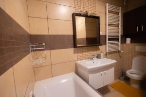 La salle de bains est pourvue d'un lavabo, d'une baignoire et de toilettes. dans l'établissement Luceafarul Property, à Oradea