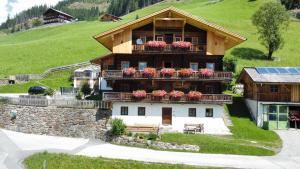 ein großes Haus mit Blumen auf dem Balkon in der Unterkunft Ferienwohnung Peintnerhof in Innervillgraten