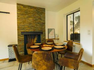 una sala da pranzo con tavolo, sedie e camino di Maison chaleureuse avec son bain enchanté ! a Mesnil-Saint-Père
