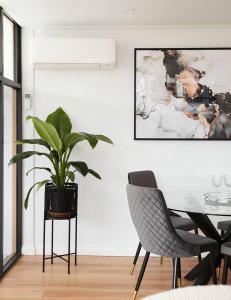 a dining room with a plant and two chairs at Found at Flinders - An Iconic City Stay in Melbourne