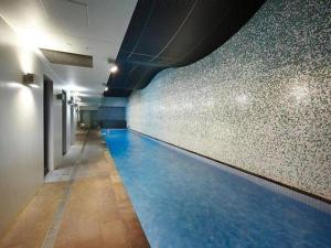 a swimming pool in a building with blue water at Skyline Allure - Urban Wellness meets City Living in Melbourne