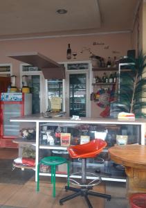a counter with a red and green stool and a table at D-Rima Homestay Ruteng in Ruteng