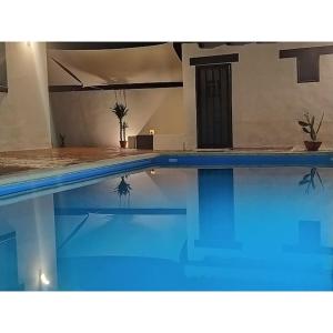 uma piscina com água azul numa casa em Casa rural la luz de Ari em Traspinedo