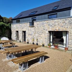 un gruppo di tavoli da picnic di fronte a un edificio in pietra di The Forum-Mountmellick - Coachhouse a Mountmellick