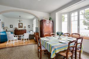 een eetkamer en een woonkamer met een tafel en stoelen bij Maison familale au panorama de reve in Saint-Cast-le-Guildo