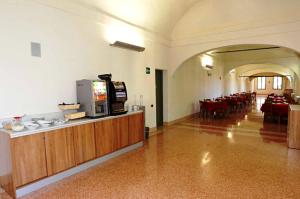 レッジョ・エミリアにあるStudent's Hostel Della Ghiaraのテーブルと椅子が備わる広い客室で、ビュッフェ式朝食が付いています。
