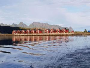a row of red houses next to a body of water at Tobiasbua in Svolvær