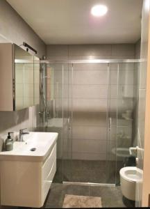 un bagno con doccia, lavandino e WC di Apartman Smokvica a Trebinje Altre 12 foto