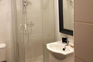 y baño con ducha acristalada y lavamanos. en Appartement au coeur du quartier de la Roquette, en Arles
