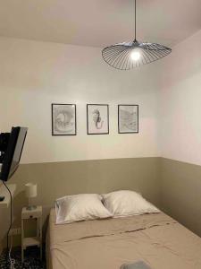 1 dormitorio con 1 cama y 3 cuadros en la pared en Appartement au coeur du quartier de la Roquette, en Arles