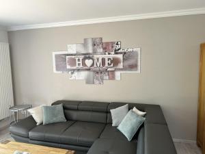 a living room with a couch and a sign that reads home at Ferienwohnung Sauerland an der Ruhr in Olsberg