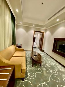 uma sala de estar com um sofá e uma mesa em فندق ركن النخبه الماسي Elite Diamond Corner - فنـــــــدق دامـاس Damas Hotel em Jeddah