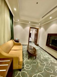 a living room with a couch and a table at فندق ركن النخبه الماسي Elite Diamond Corner - فنـــــــدق دامـاس Damas Hotel in Jeddah