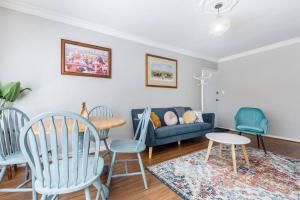 - un salon avec des fauteuils bleus et un canapé bleu dans l'établissement Rosewood Lodge - Cottage Charm off High Street, à Melbourne