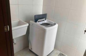 La salle de bains est pourvue de toilettes blanches et d'un lavabo. dans l'établissement Bonito apartamento Cocha, à Cochabamba