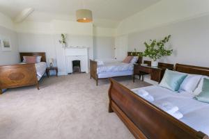 a living room with two beds and a fireplace at Plas Cichle in Beaumaris