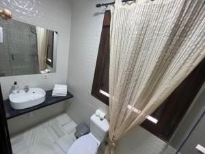 baño con lavabo y aseo y ventana en Hostal el Pasaje, en Puente Genil
