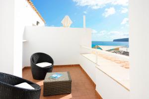 a balcony with chairs and a view of the ocean at Apartamentos Es Caló in Es Calo