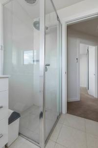 a glass shower in a bathroom with a hallway at Trendy and Spacious Brunswick Stay with Outdoor Deck in Melbourne