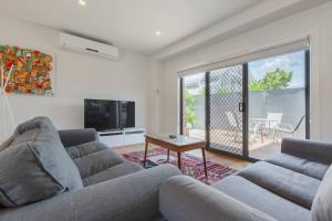 a living room with a couch and a television at Trendy and Spacious Brunswick Stay with Outdoor Deck in Melbourne