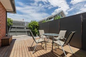 a patio with a table and chairs on a balcony at Trendy and Spacious Brunswick Stay with Outdoor Deck in Melbourne