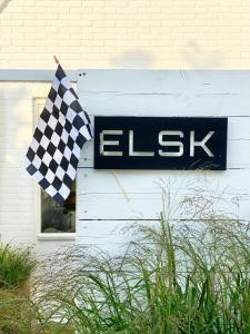 eine karierte Flagge neben einem Schild auf einem Haus in der Unterkunft ELSK Cottage in Zandvoort
