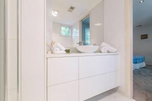 Un baño blanco con lavabo y espejo. en The Poppy - Townhouse Chic with Country Flair, en Melbourne 19 fotos más