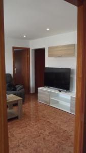 ein Wohnzimmer mit einem großen Flachbild-TV in der Unterkunft Apartamentos Atlas Terrassa I in Terrassa