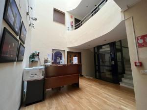 a hallway with a staircase in a building with a desk at Hostal el Pasaje in Puente-Genil