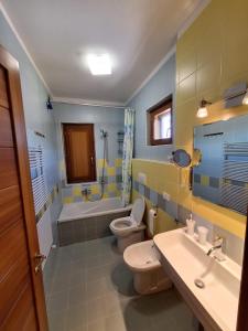 uma casa de banho com 2 WC, uma banheira e um lavatório. em Villa Scarialetto nel Parco Naturale di Monte Cucco em Sigillo