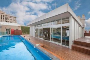 a house with a swimming pool and a building at Easy Eastside - A Sunny Rooftop Pool Oasis in Melbourne