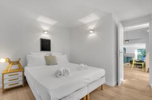 1 dormitorio con 1 cama blanca y 2 toallas en Le Jardin de Lucette - Belle maison avec jardin arboré dans Toulouse, en Toulouse