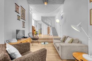 un soggiorno con un divano e una TV di Le Jardin de Lucette - Belle maison avec jardin arboré dans Toulouse a Tolosa
