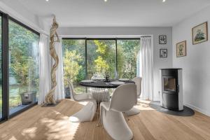 ein Esszimmer mit einem Tisch, Stühlen und einem Kamin in der Unterkunft Le Jardin de Lucette - Belle maison avec jardin arboré dans Toulouse in Toulouse