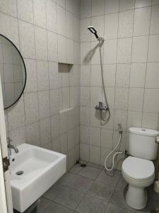 ein Bad mit einem WC, einem Waschbecken und einer Dusche in der Unterkunft Apartemen MTC Unit 626 in Manado