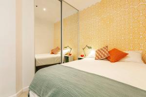 a bedroom with two beds with orange pillows at Stylish Treetop Escape on Buzzing Swanston Street in Melbourne