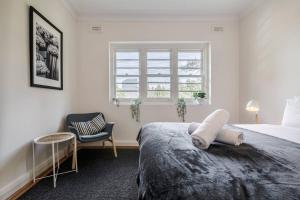 a bedroom with a bed and a chair and a window at Port Phillip Bay Perfection in Albert Park in Melbourne