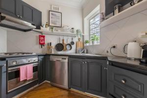 a kitchen with gray cabinets and a sink and a stove at Port Phillip Bay Perfection in Albert Park in Melbourne