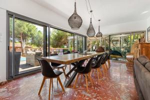 a dining room with a long table and chairs at Villa Mercure in Cap d'Agde