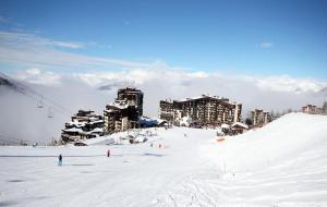 a snow covered slope with people on a ski resort at Hôtel Les Écrins in Les Orres