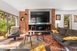 a living room with a couch and a tv at Villa Mercure in Cap d'Agde