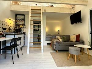 a living room with a loft bed and a kitchen at Chata Lila Bee in Hodruša