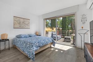 a bedroom with a bed and a sliding glass door at Villa Mercure in Cap d'Agde +15 photos