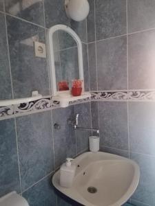 uma casa de banho com um lavatório e um espelho em Apartman Marinamar em Utjeha