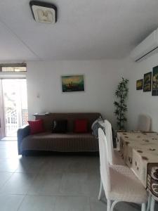 uma sala de estar com um sofá e uma mesa em Apartman Marinamar em Utjeha